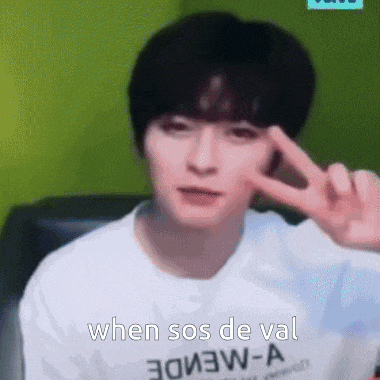 a man in a white shirt is making a peace sign with his finger .