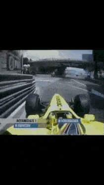 a yellow race car with the number 1 on the side is going down a track