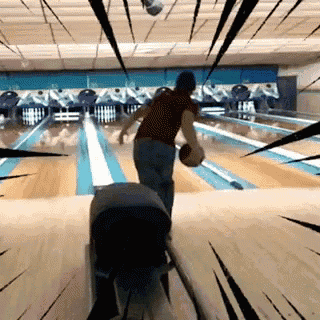 a man is throwing a bowling ball in a bowling alley .