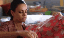 a woman is holding a red bag in her hands .