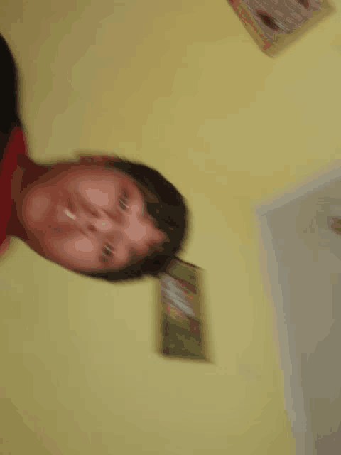 a blurry picture of a person 's face with a yellow wall in the background