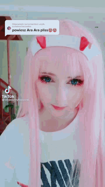 a girl with pink hair and blue eyes is wearing a white nike shirt