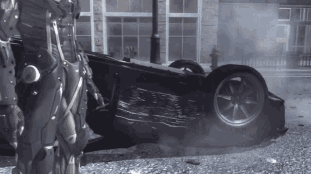 a man in armor is standing next to a car that has turned on its side