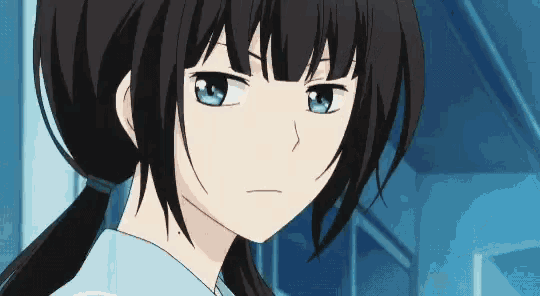 a girl with dark hair and blue eyes is wearing a blue shirt