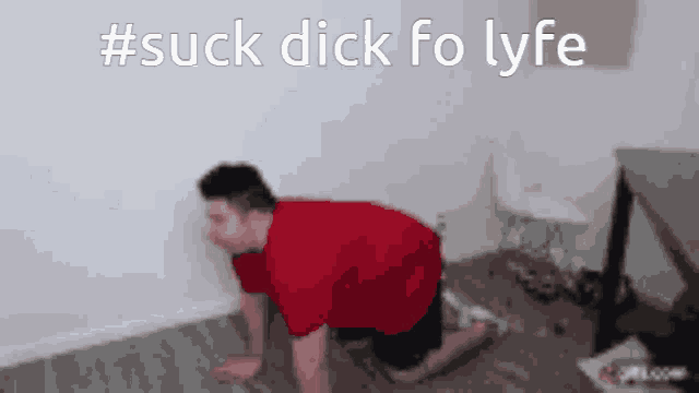 a man in a red shirt is crawling on the floor with the words #suck dick fo lyfe behind him