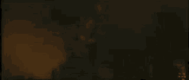 a blurry picture of a person in a dark room with a fire in the background .