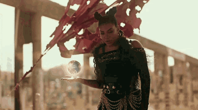 a woman in a devil costume is holding a crystal ball
