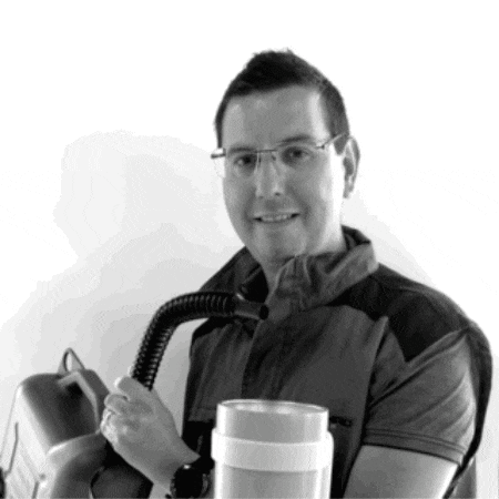 a man wearing glasses is holding a vacuum cleaner and smiling for the camera