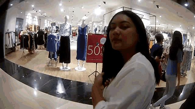 a woman is standing in front of a sign that says 50 % off
