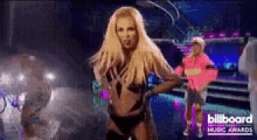 a woman is dancing on a stage in front of a billboard sign