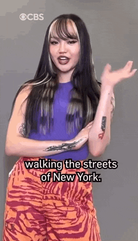 a woman is walking down the streets of new york while wearing zebra print pants .