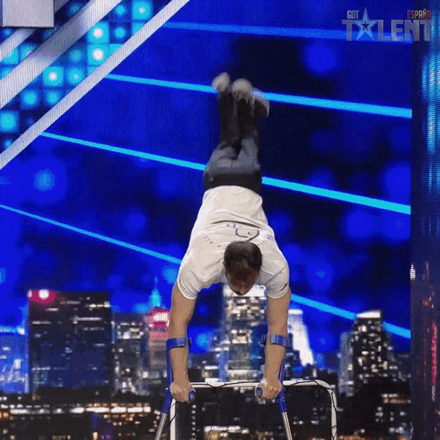 a man is doing a handstand on parallel bars on a got talent show