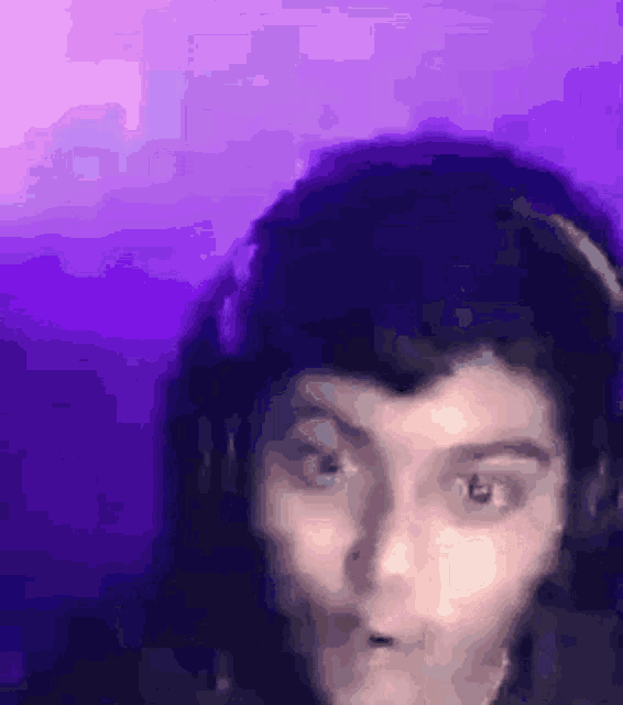 a woman is wearing headphones and making a funny face .