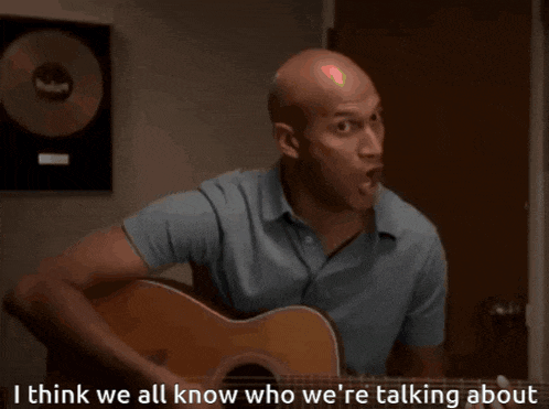 a man playing a guitar with the words " i think we all know who we 're talking about " above him