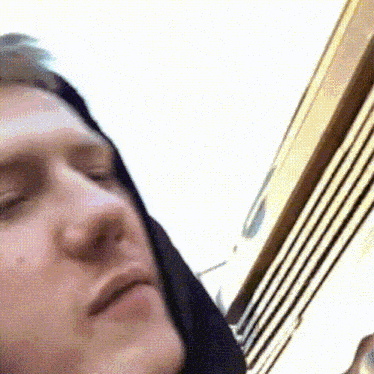 a close up of a man 's face with a hood on his head .