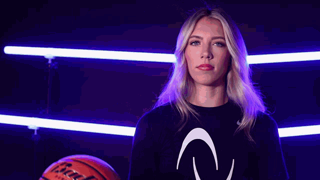 a woman in a black shirt is holding a basketball that says " gatorade " on it