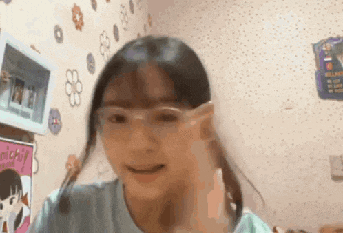 a young girl wearing glasses is making a funny face .