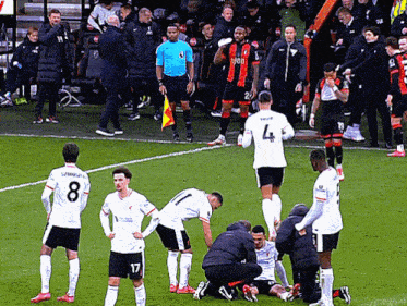 a soccer player with the number 4 on his jersey is being helped on the field