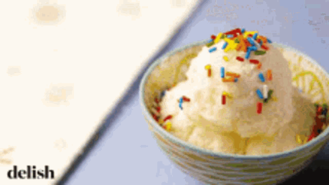 a bowl of ice cream with sprinkles on top and the word delish in the corner