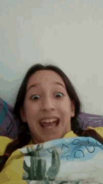 a young girl is making a funny face while laying on a bed