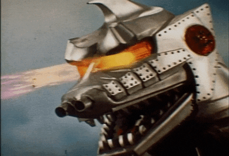 a close up of a robot 's head with fire coming out of its mouth