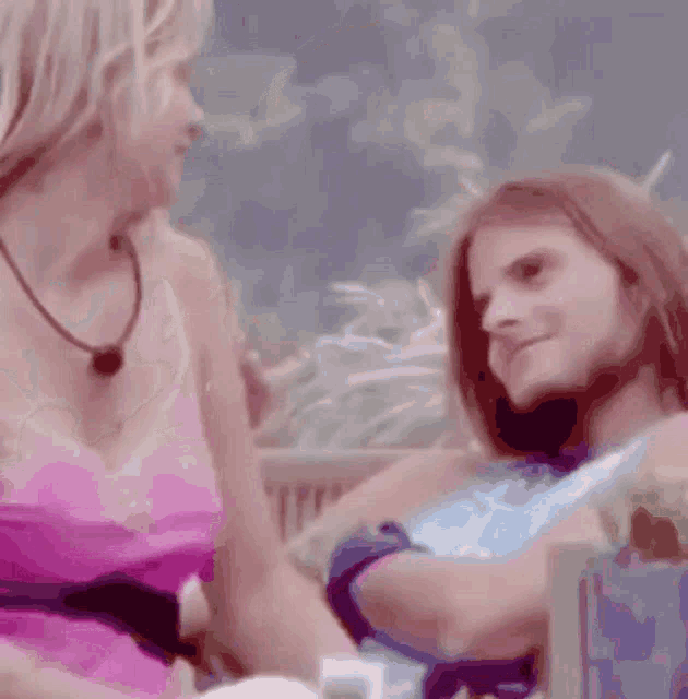 two women are sitting next to each other and one is clapping her hands