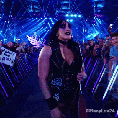 a woman stands in front of a crowd holding a guitar and a sign that says welcome home mary