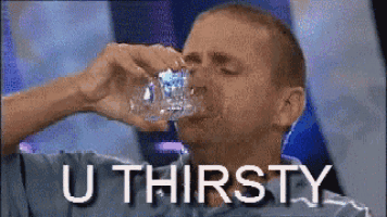 a man is drinking water from a glass with the words u thirsty written on the bottom .