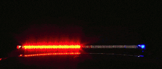 a blue light is shining in the dark with a red light in the background