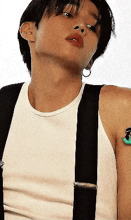 a man wearing suspenders and a white tank top .