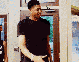 a man in a black shirt is standing in front of a door that has the number 3 on it