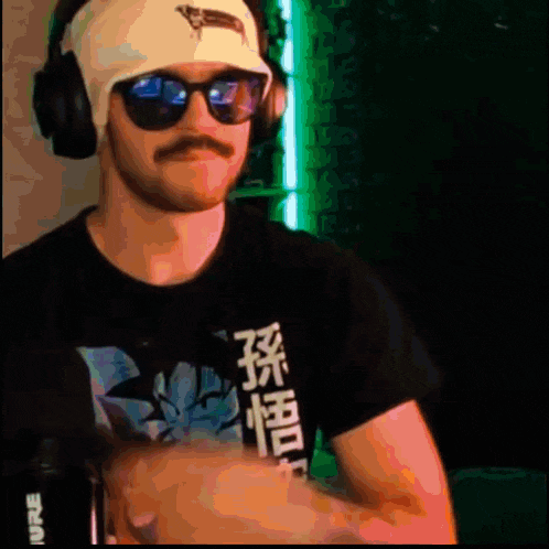 a man wearing headphones and sunglasses has a shirt with chinese writing