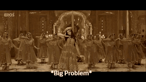 a woman in a gold dress is standing in front of a group of women dancing .