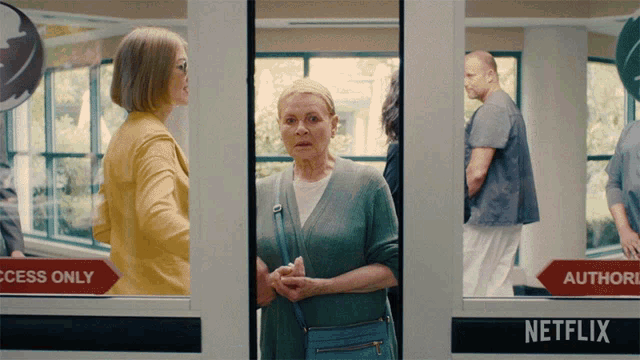 a woman stands in front of a door that says netflix