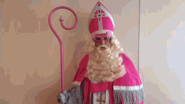a statue of a man in a pink costume with a cane