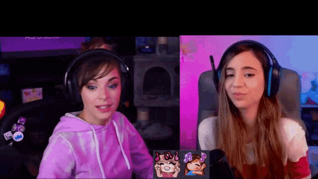 two women wearing headphones are sitting in front of a computer screen