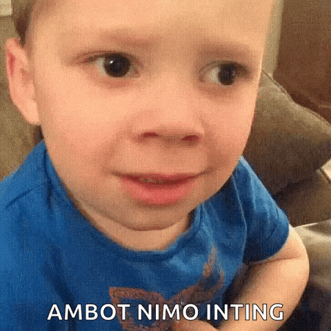 a young boy in a blue shirt is making a funny face and says ambot nimo inting .