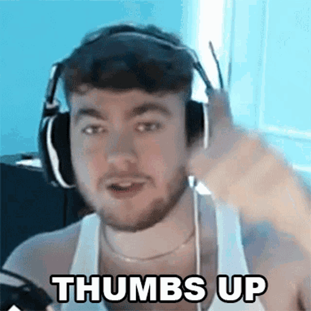 a man is wearing headphones and giving a thumbs up .