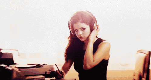 a woman wearing headphones is sitting in front of a turntable