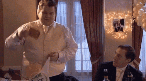 a man in a tuxedo is pouring beer into a glass .