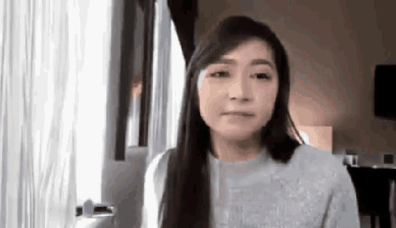 a woman with long hair is sitting in front of a computer screen in a room .