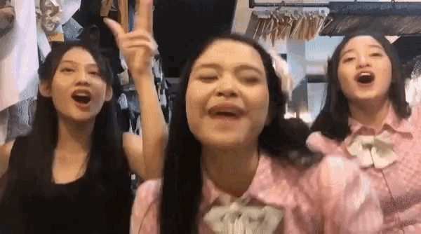three girls are standing next to each other and singing