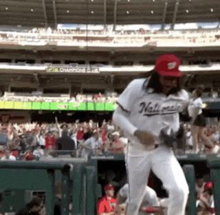 a man wearing a nationals jersey is dancing in a stadium