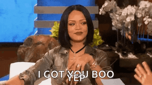 a woman is sitting on a couch and saying `` i got you boo '' while talking to someone .