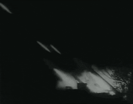 a black and white photo of a jet flying through the night sky