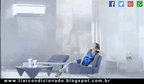 a woman in a blue dress sits in a chair in front of a wall air conditioner
