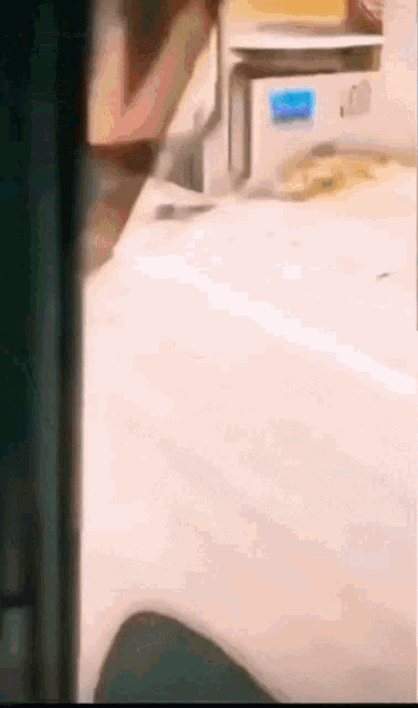 a person is standing in front of a microwave with a blue sticker on it