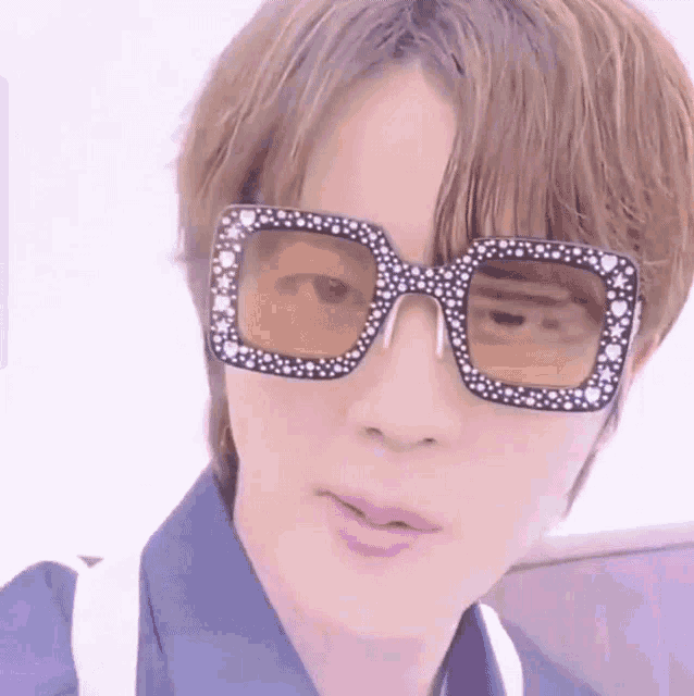 a close up of a person wearing sunglasses with rhinestones .