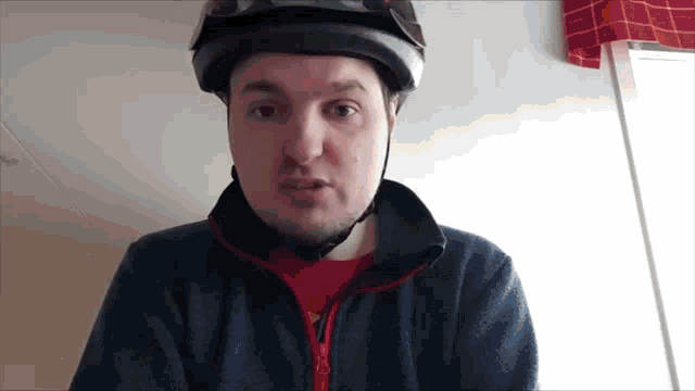a man wearing a helmet and a blue sweater