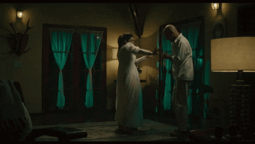 a man and a woman are dancing in a dark room